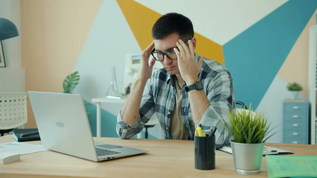 Exploitant stressé devant son ordinateur.